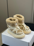 Pair of Moncler shearling boots with light tan fuzzy cuffs and white lace-up front