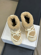 Moncler lace-up shearling boots in light tan, shown side by side on a box