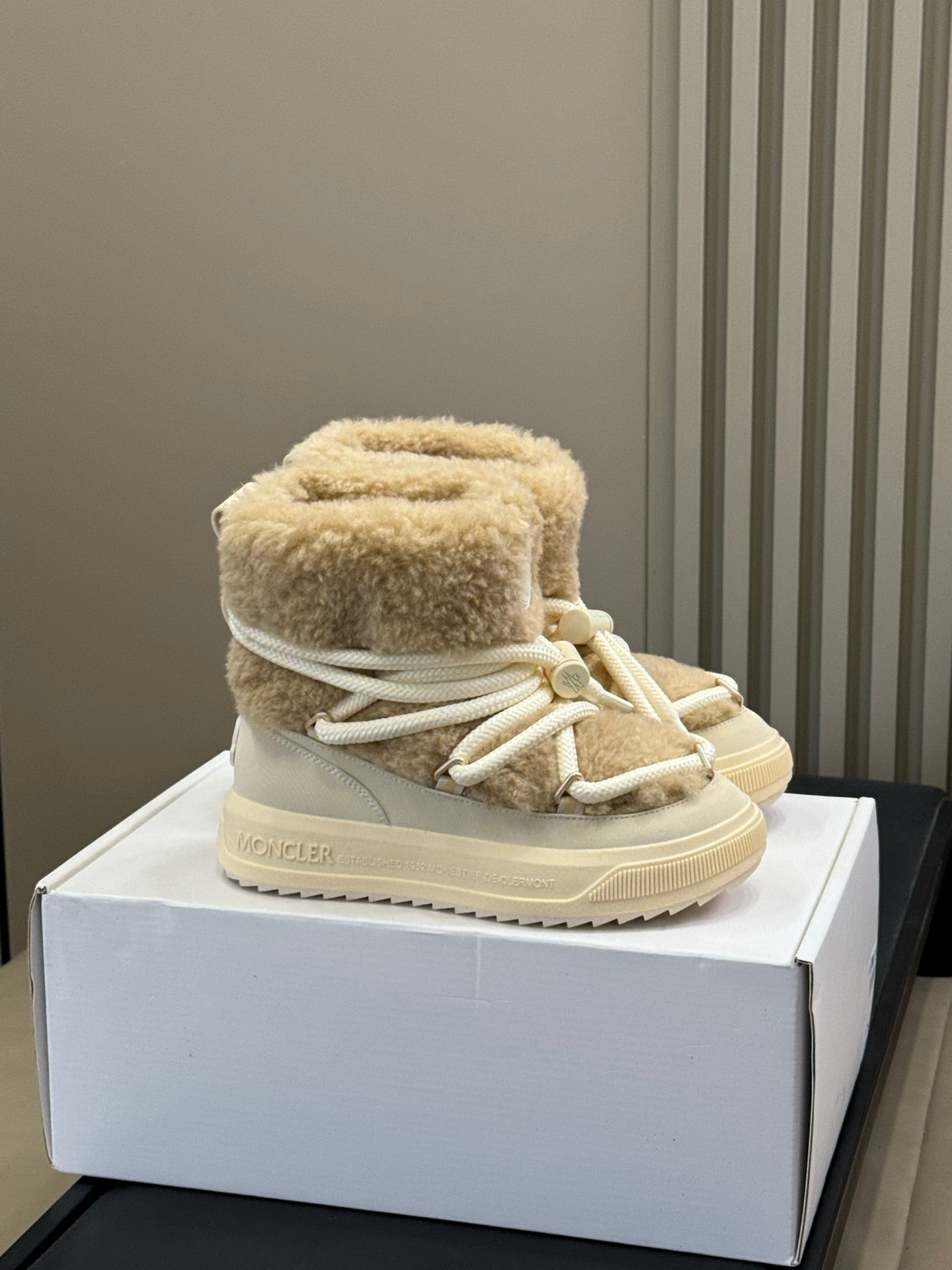 Moncler shearling ankle boots in light tan with white laces and textured soles