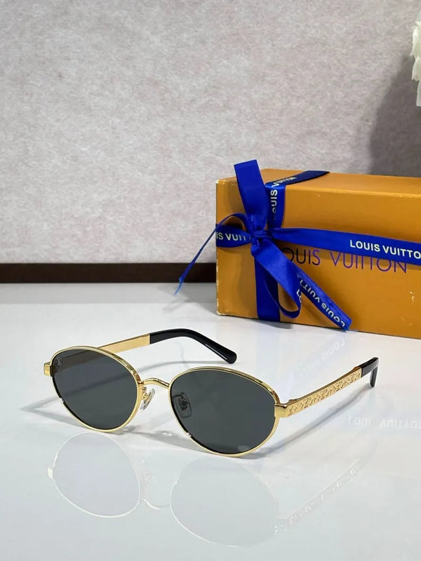 Oval sunglasses with dark lenses and gold-tone metal frame, black nose bridge detail