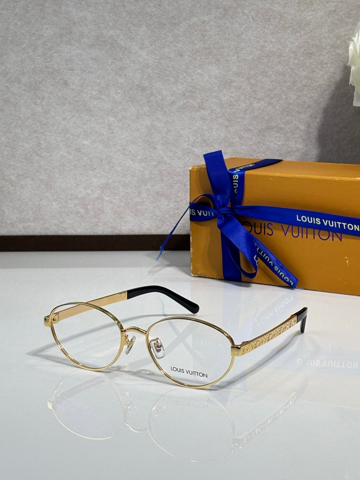 Gold round eyeglasses with clear lenses and thin black temple tips