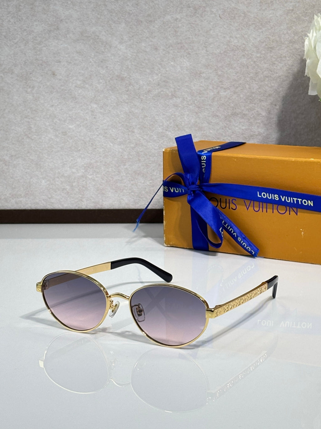Gold round sunglasses with purple-tinted lenses and black temple tips