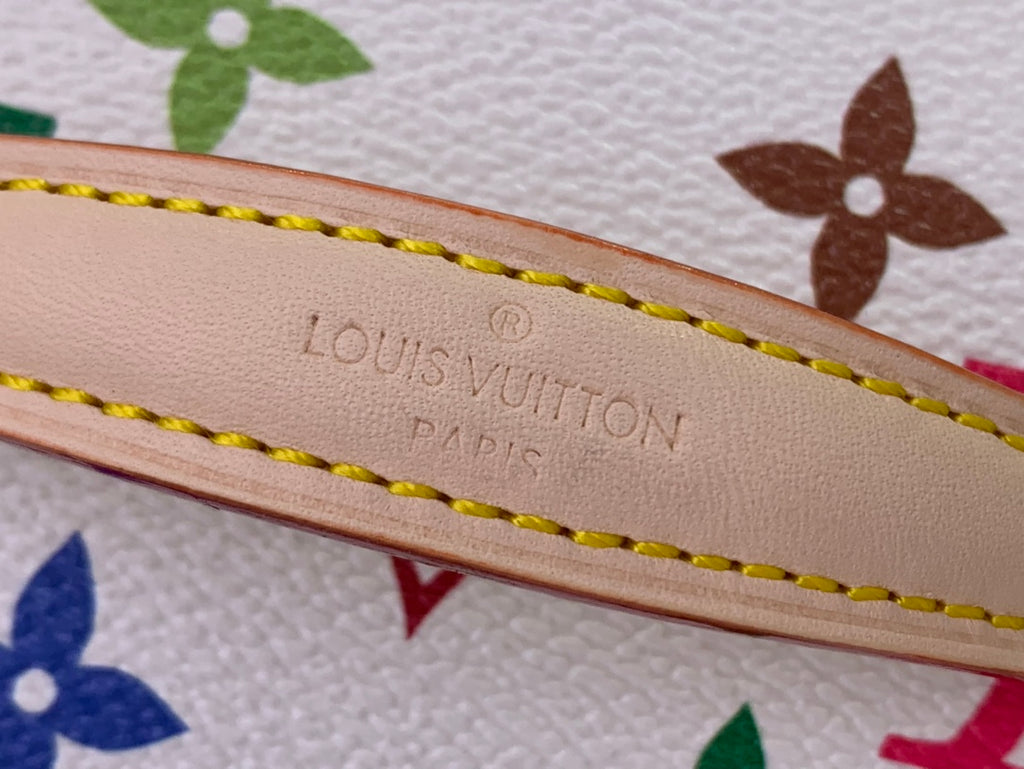Louis Vuitton monogram bag strap detail with embossed branding and yellow stitching