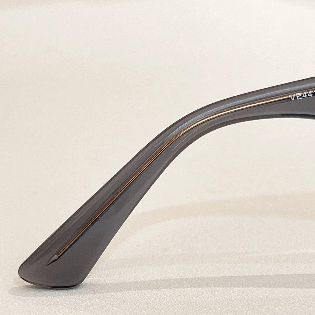 Clear gray sunglasses temple with metallic logo mark
