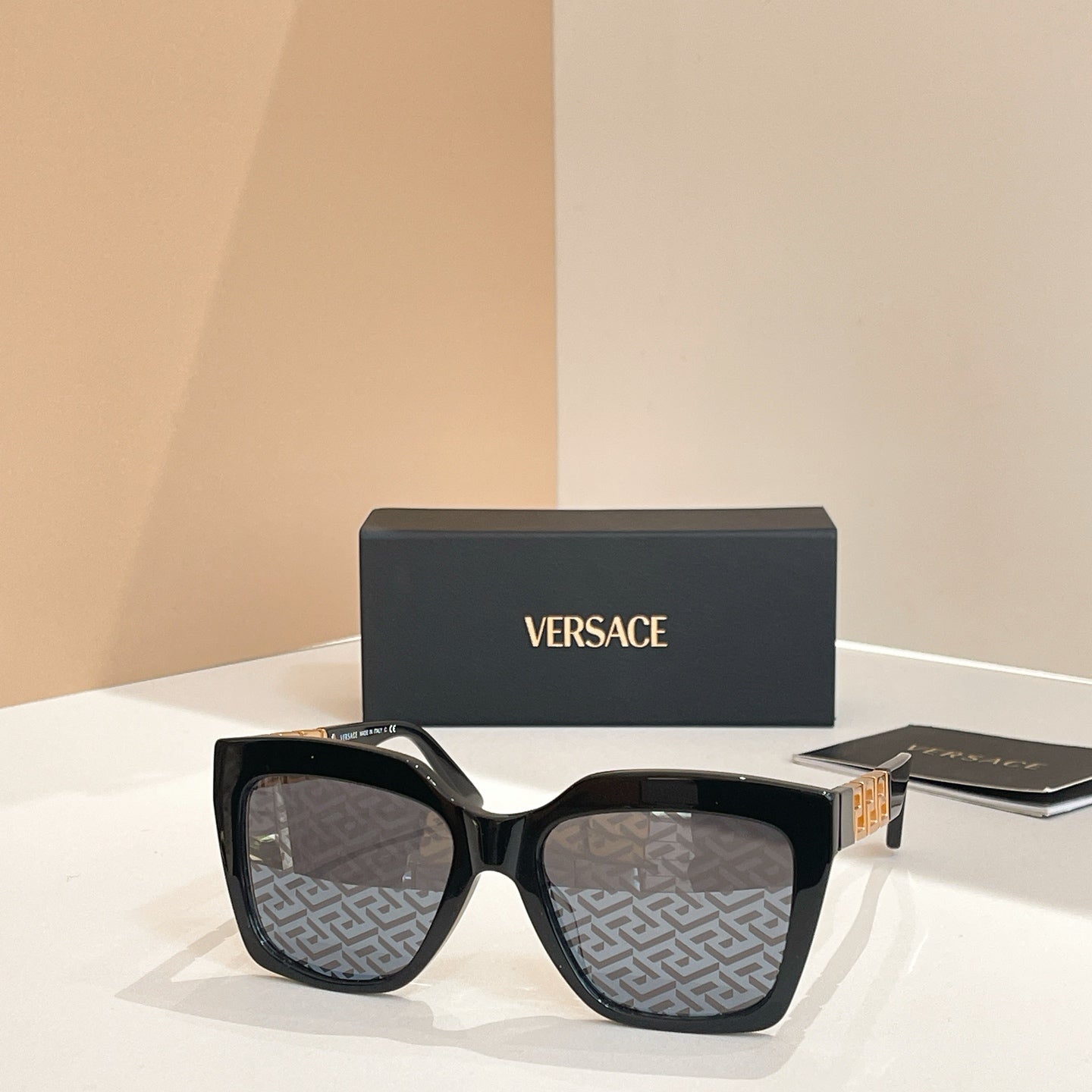 Black square sunglasses with dark patterned lenses and thick frame