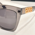 Clear gray sunglasses temple with gold geometric logo detail