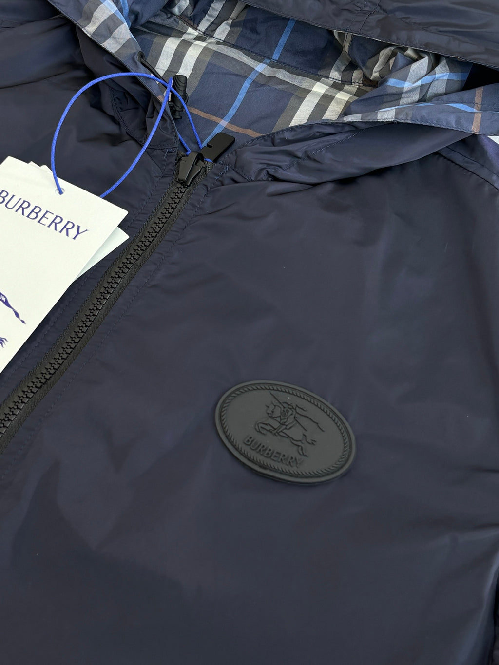 Burberry navy hooded jacket chest close-up with round logo patch and zipper