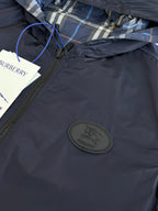 Burberry navy hooded jacket chest close-up with round logo patch and zipper