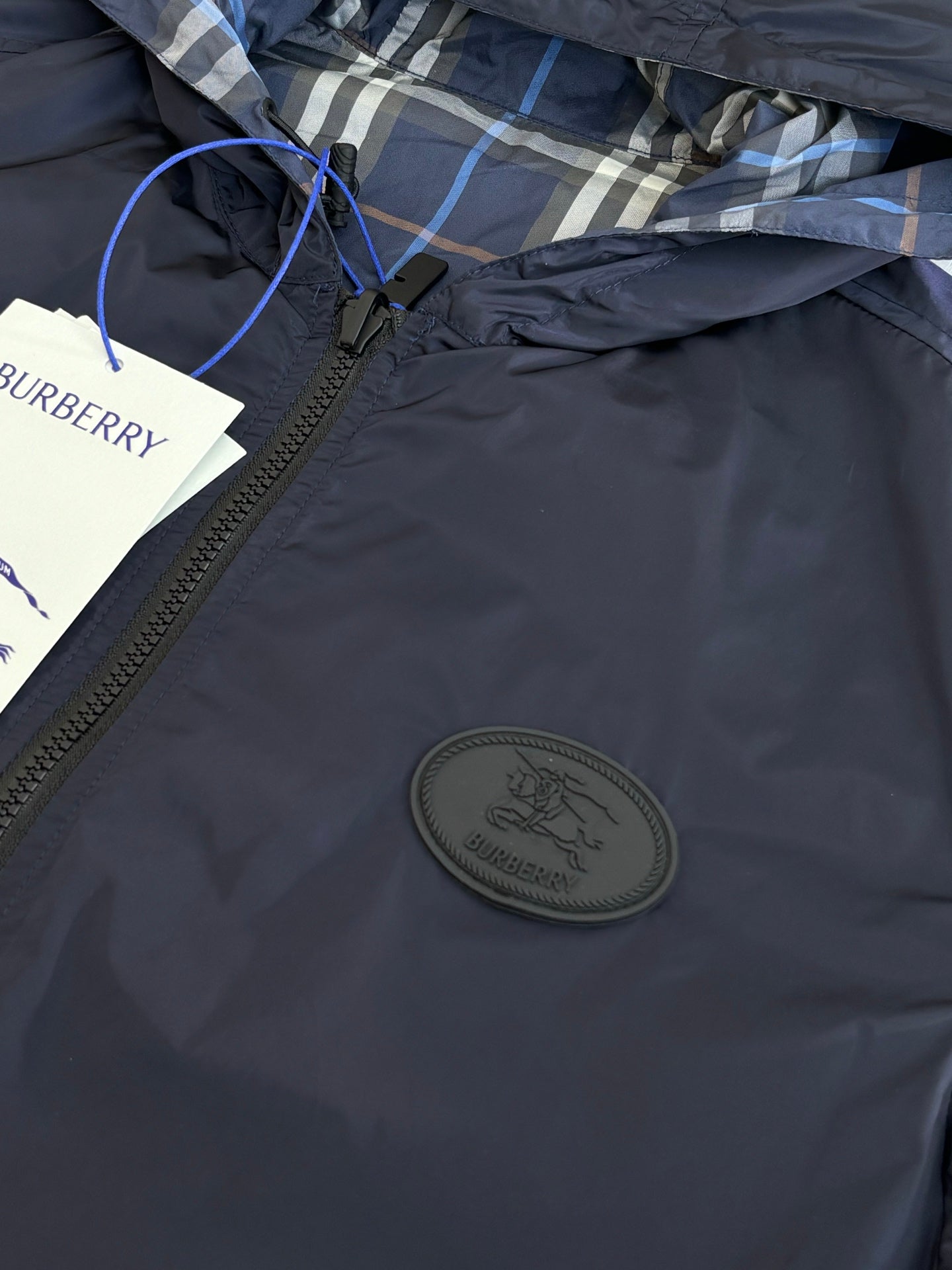 Burberry navy hooded jacket chest close-up with round logo patch and zipper