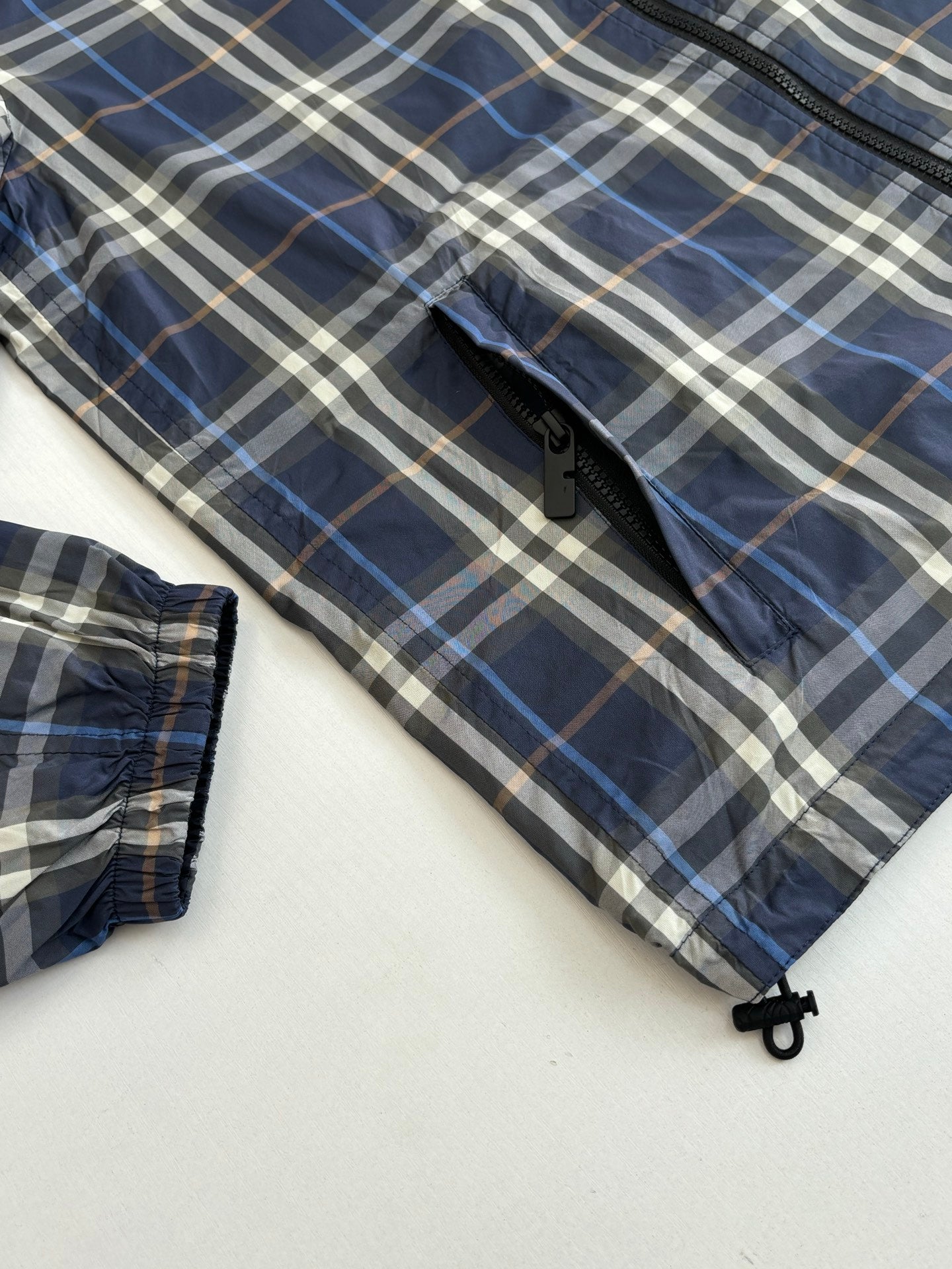 Burberry blue plaid sleeve and cuff close-up with zipper and snap detail