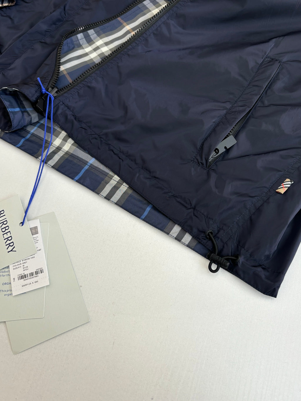 Burberry navy jacket close-up with inner plaid hood lining and branded tag