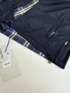 Burberry navy jacket close-up with inner plaid hood lining and branded tag