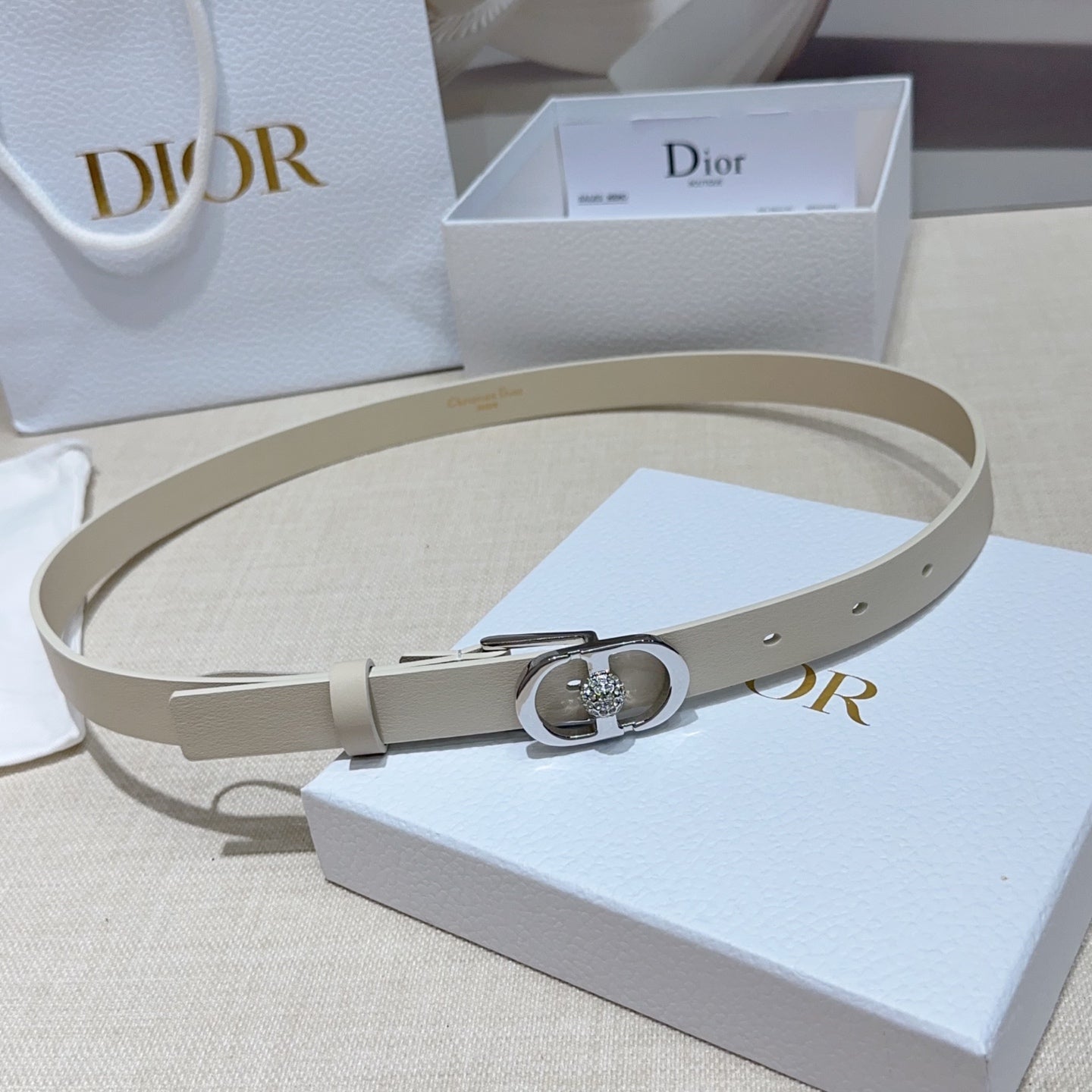 Light leather Dior-style belt with silver oval buckle and rhinestone heart detail