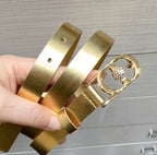 Dior gold-tone belt with oval buckle and round rhinestone detail, shown in hand