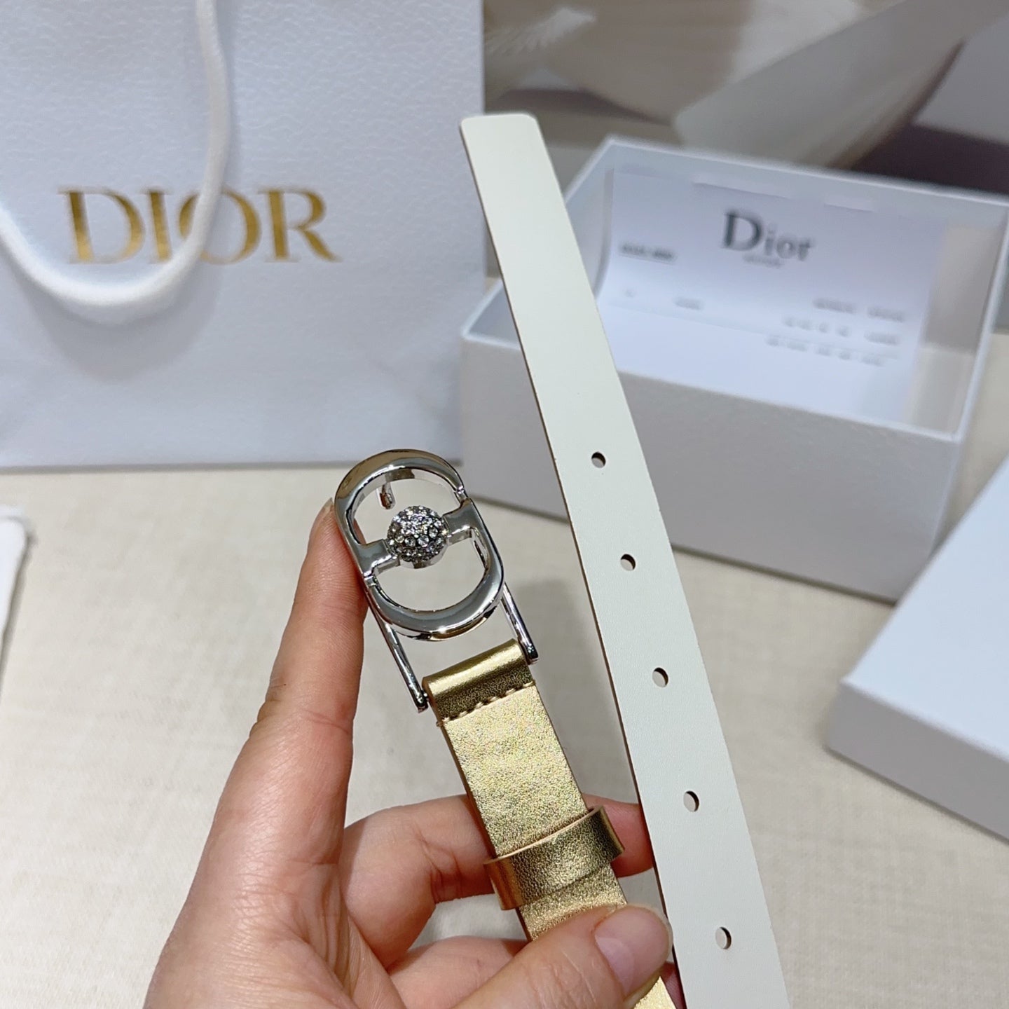 Gold belt with silver oval buckle, crystal center, and adjustable punched strap