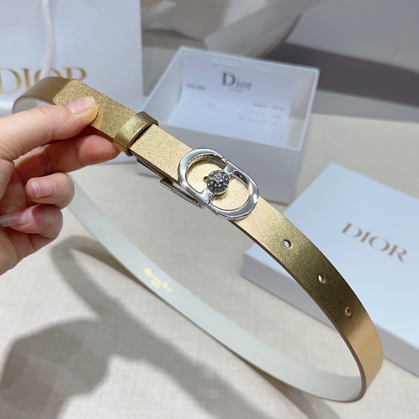 Gold leather belt strap with silver buckle loop and crystal bezel