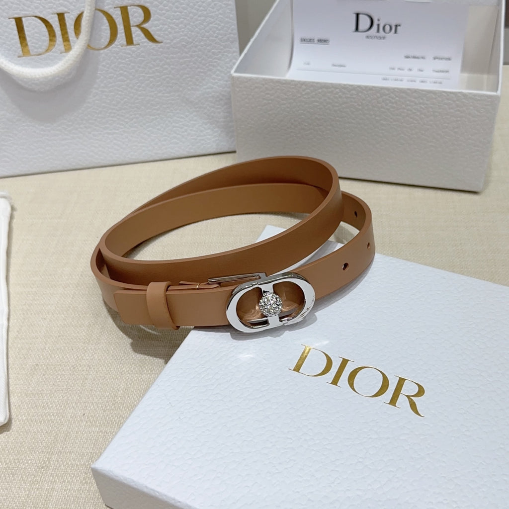 Tan leather belt with silver buckle featuring a round jeweled clasp