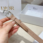 Tan leather belt with silver buckle and round jeweled accent, close-up