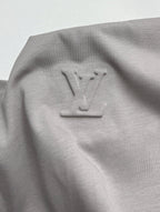 Light gray T-shirt with embossed-style LV emblem near upper back