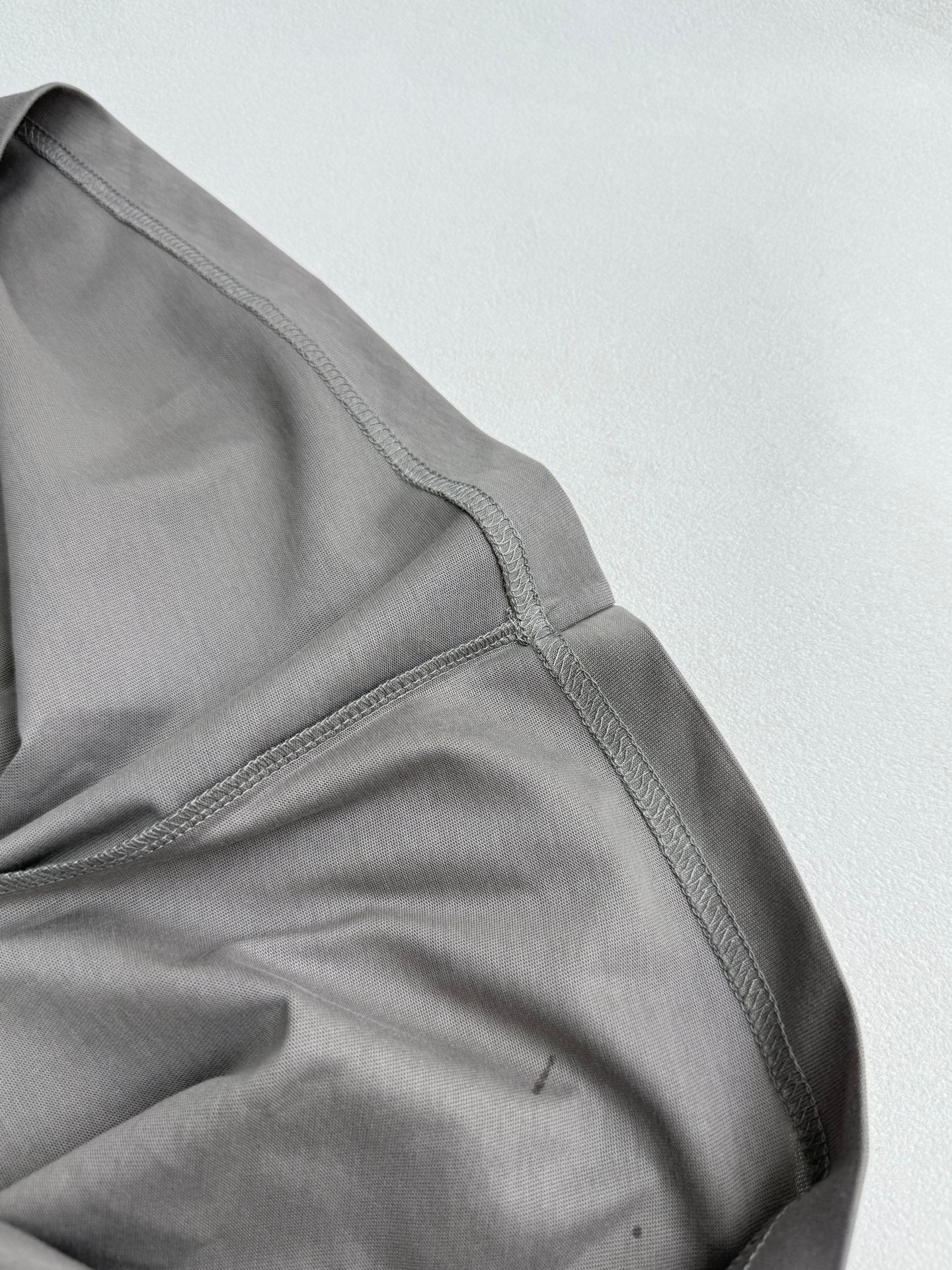 Light gray short-sleeve T-shirt with shoulder seam and sleeve hem detail
