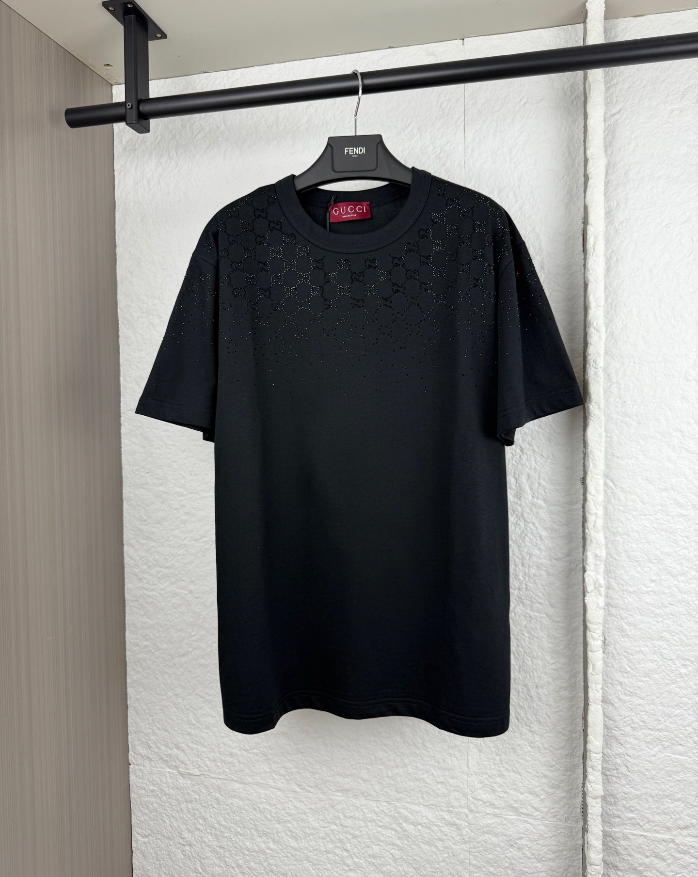 Black short-sleeve T-shirt with subtle logo pattern