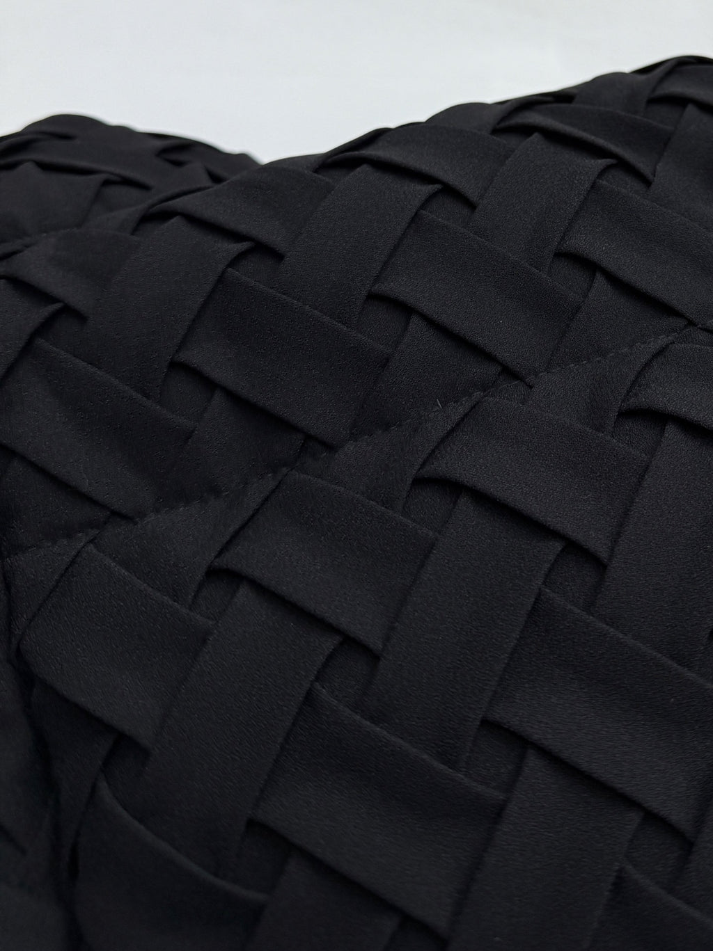 Close-up of black woven-texture jacket fabric panel