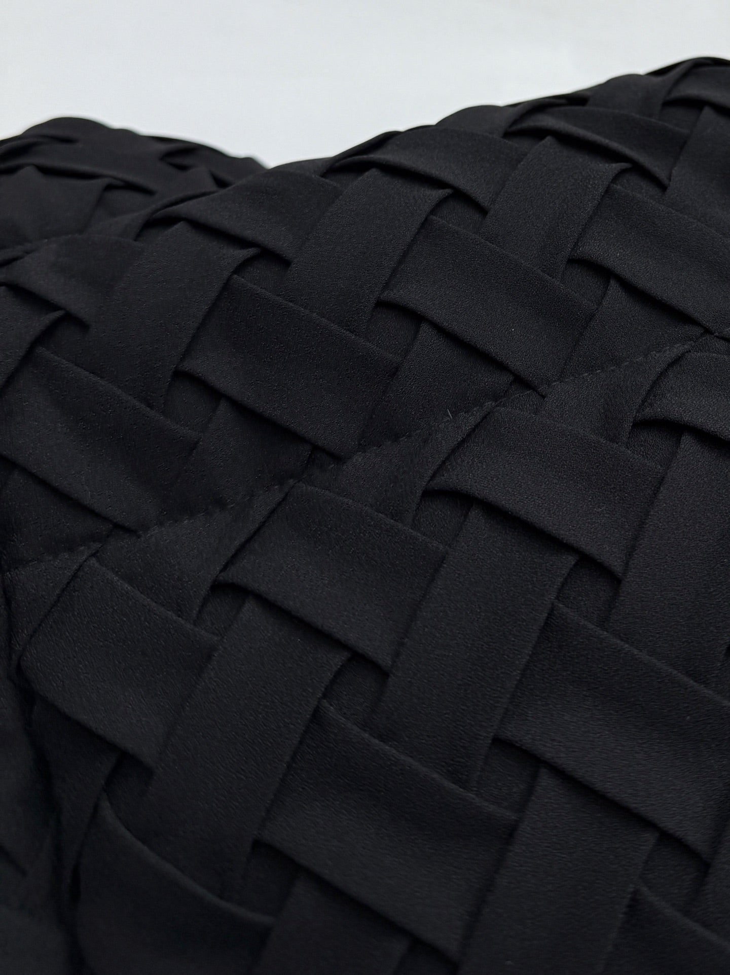 Close-up of black woven-texture jacket fabric panel