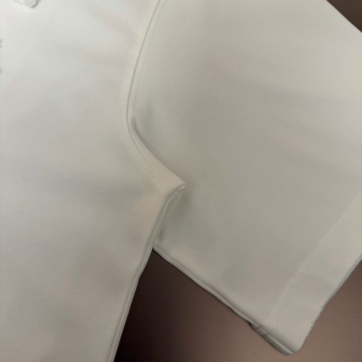White T-shirt sleeve hem and side seam close-up