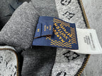 Louis Vuitton hooded jacket interior tag and blue label near zipper, on gray fabric