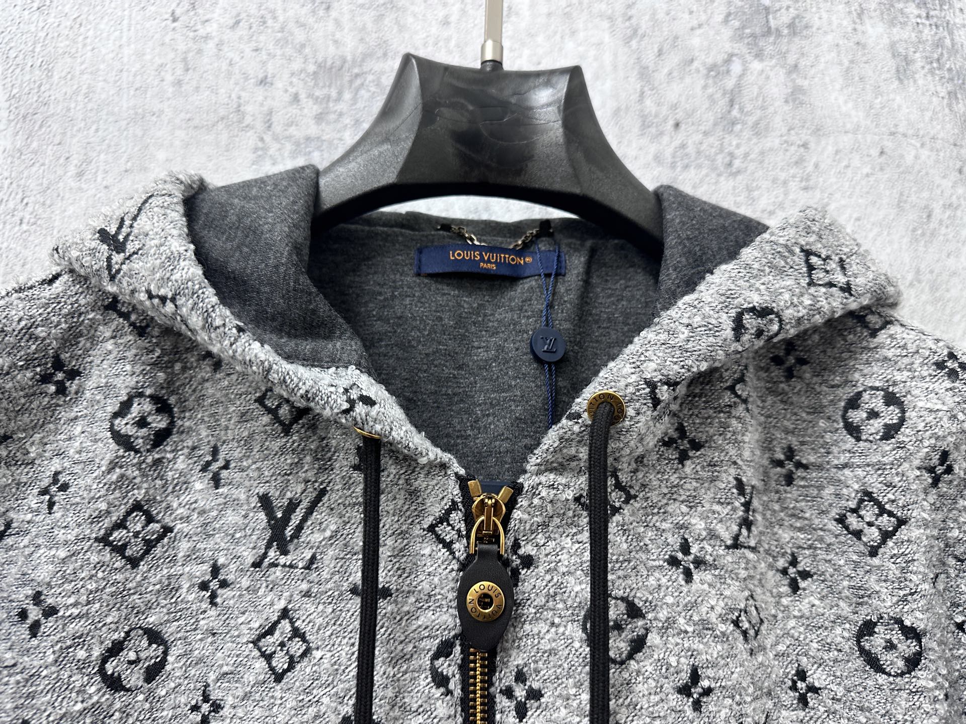 Louis Vuitton hooded jacket neckline close-up with gray lining, zipper, and monogram print