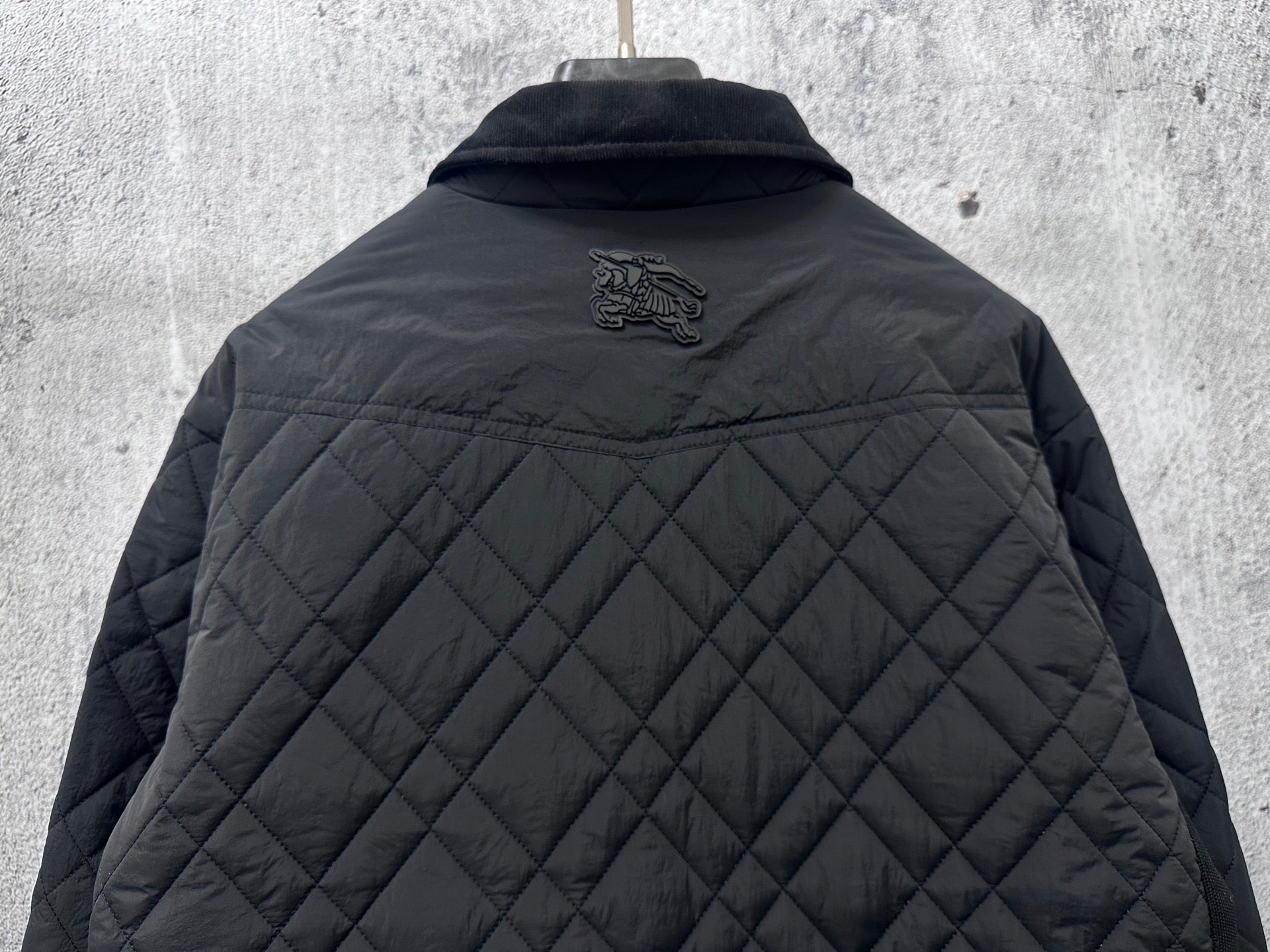 Burberry long quilted jacket back view with small crest logo above quilting