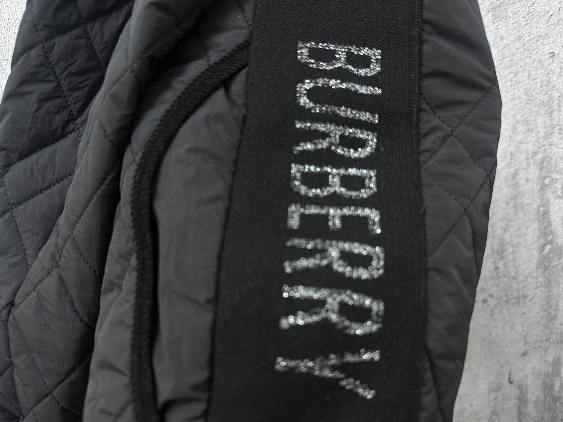 Burberry long jacket interior label text on dark fabric near zipper