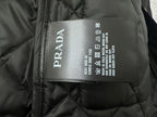 Prada size label inside dark quilted jacket lining with care icons