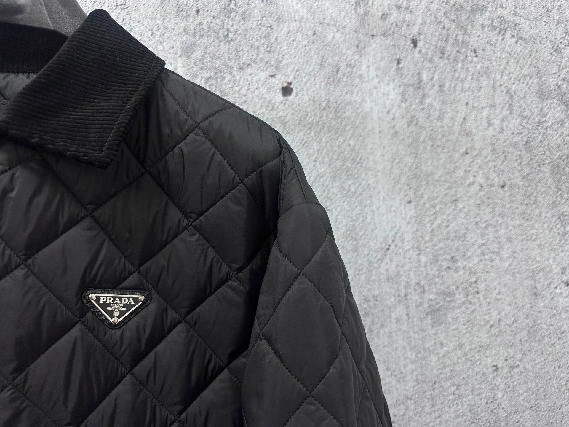 Prada logo badge on quilted dark black long jacket with diamond pattern