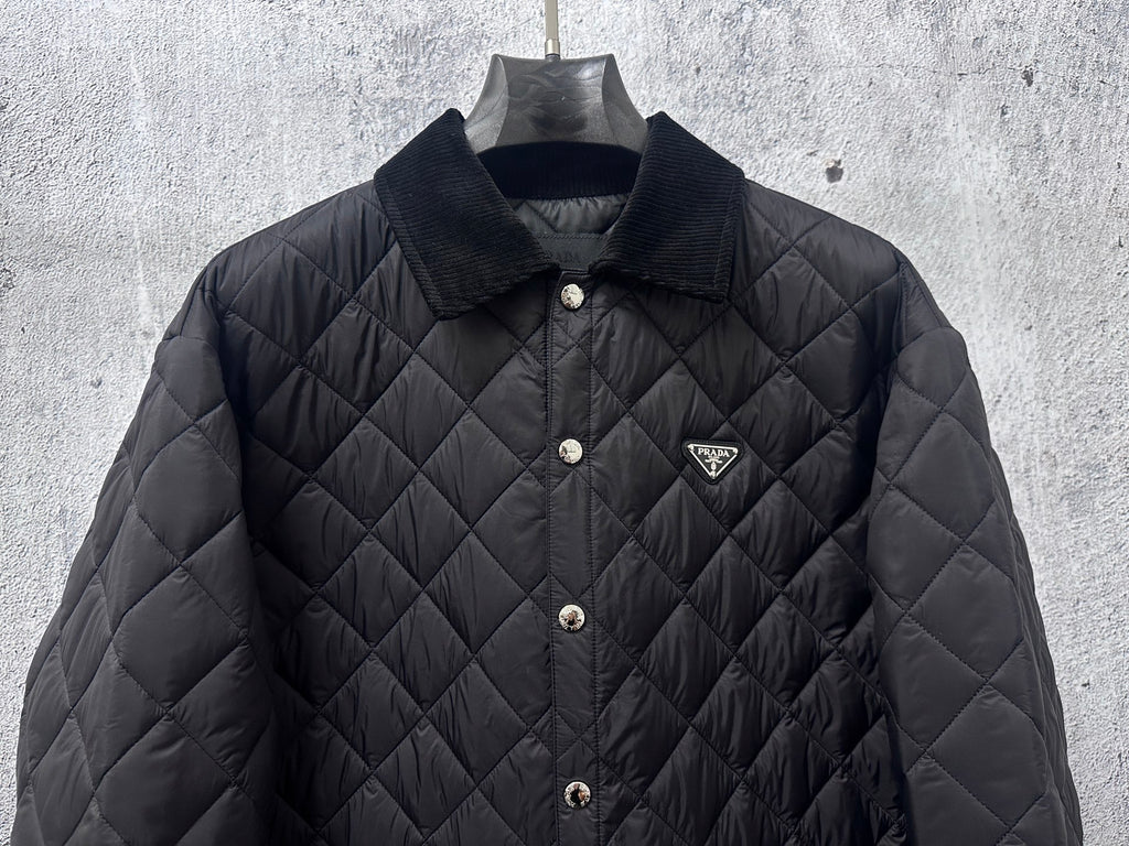 Prada quilted long jacket in dark black with chest logo and snap front