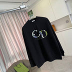 Black long-sleeve crewneck sweatshirt with colorful crest graphic print, angled