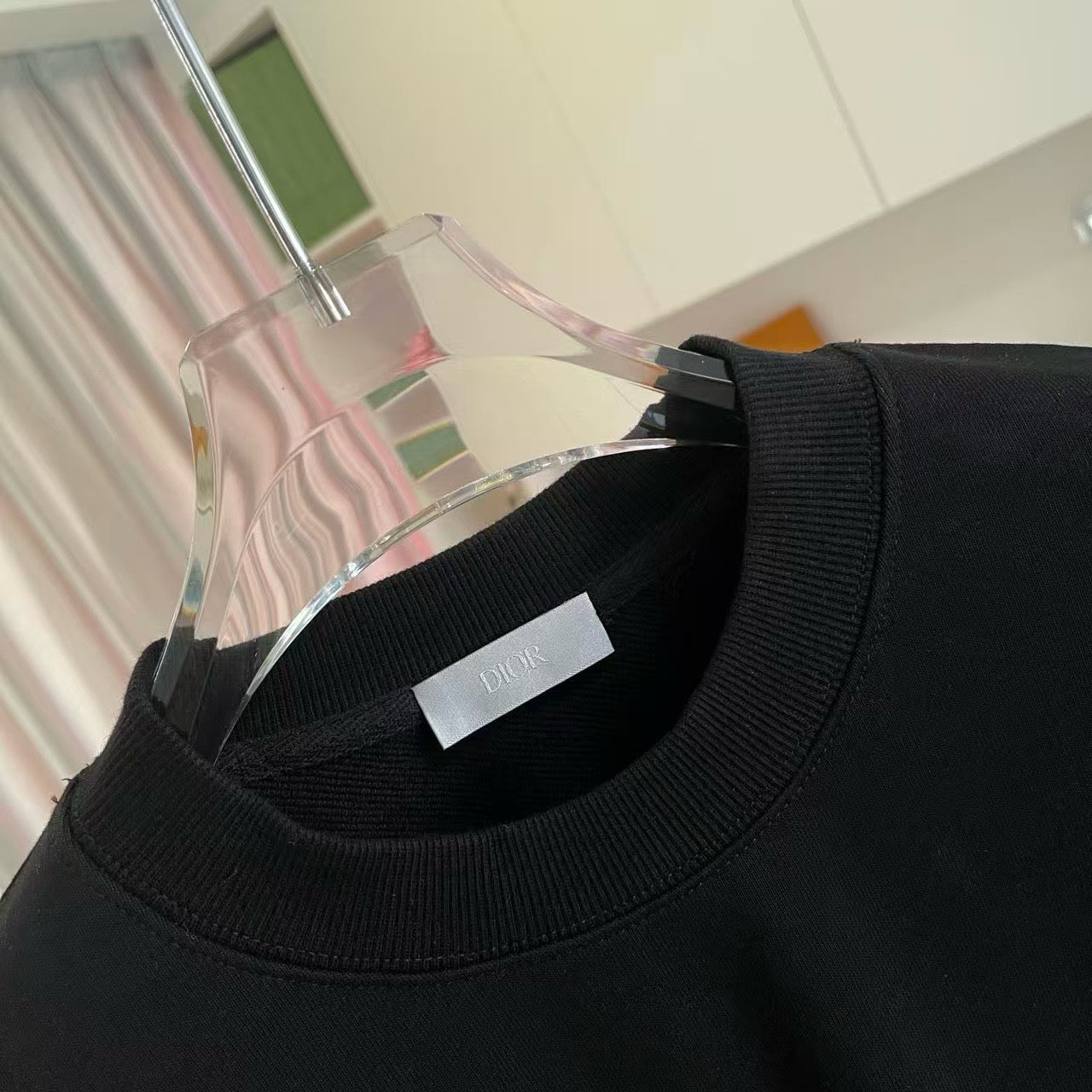 Black crewneck sweatshirt neckline with ribbed collar and white size label