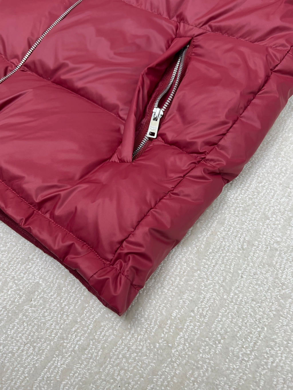 Prada red puffer jacket bottom hem with front zipper and stitched padding