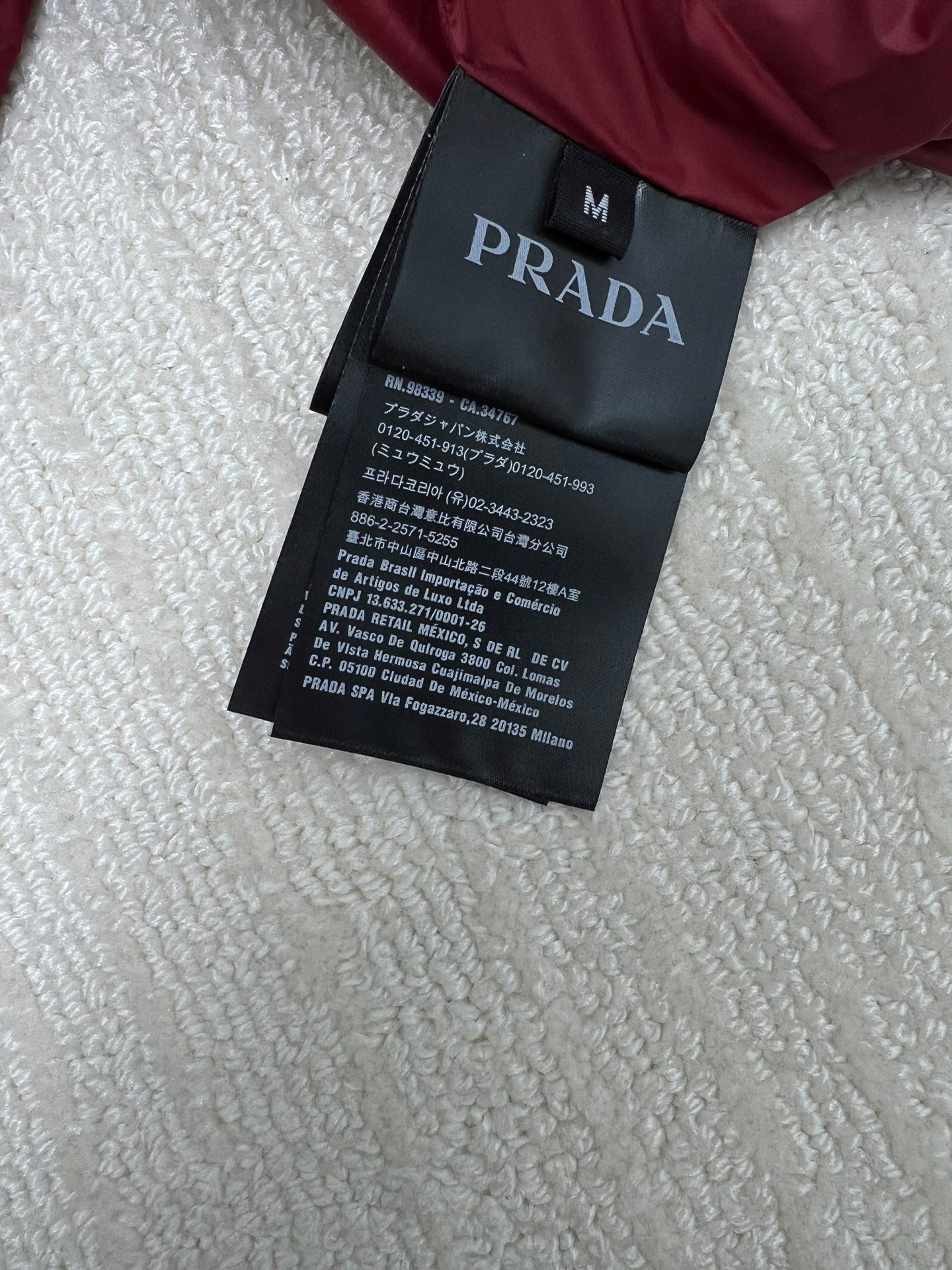 Prada label tag on long padded jacket with size and care text