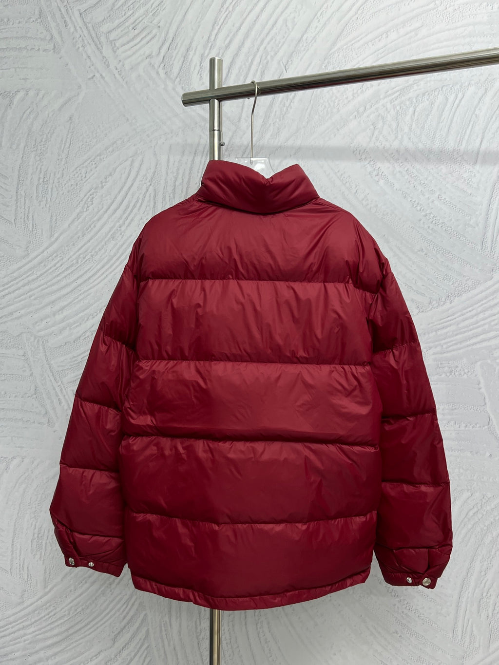 Prada red puffer jacket, back view with raised hood and padded panels