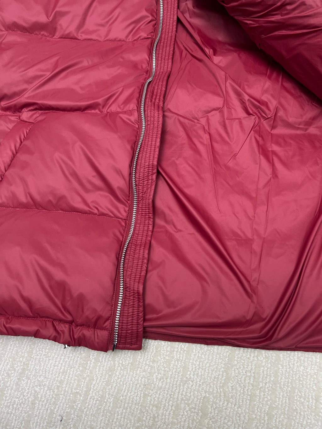 Prada red puffer jacket close-up of front zipper and inner placket