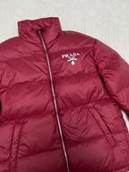 Prada red puffer jacket with stand collar, front zipper, and PRADA logo