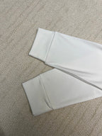 White long-sleeve shirt folded flat on textured surface