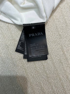 White long-sleeve shirt with size M and PRADA care label at neckline
