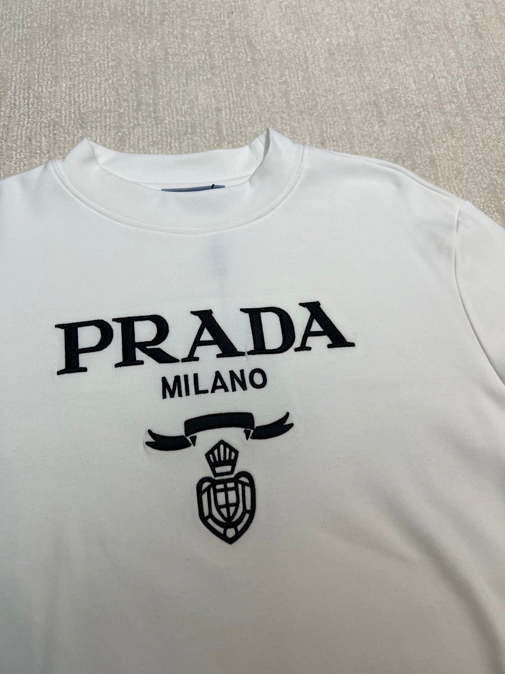 White long-sleeve shirt with PRADA MILANO text and crest emblem print