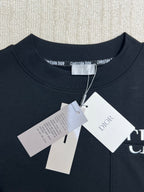 Dark crewneck sweatshirt with brand neck label and attached white tag pack
