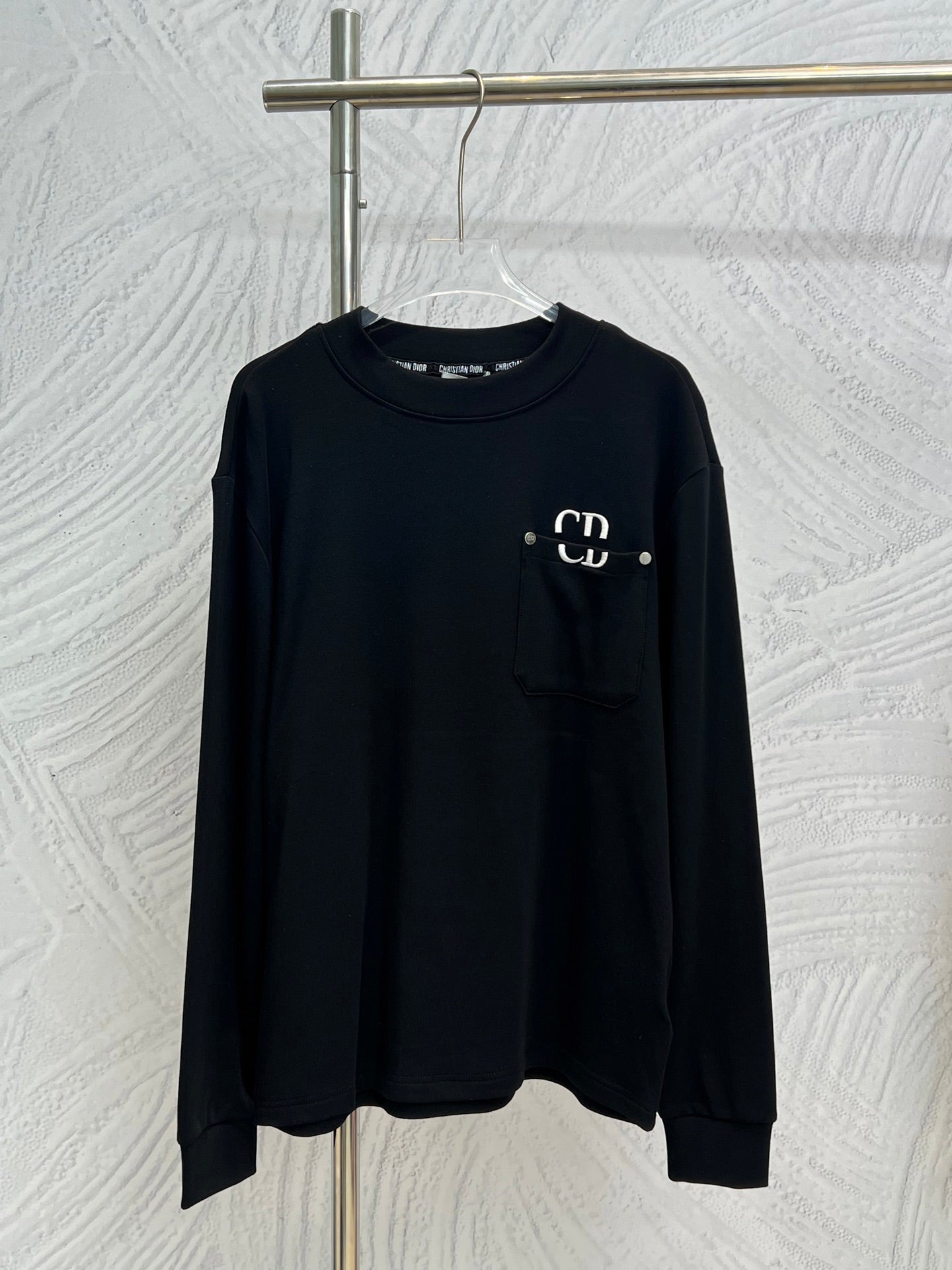 Dark crewneck long-sleeve sweatshirt with chest pocket and white CD logo detail