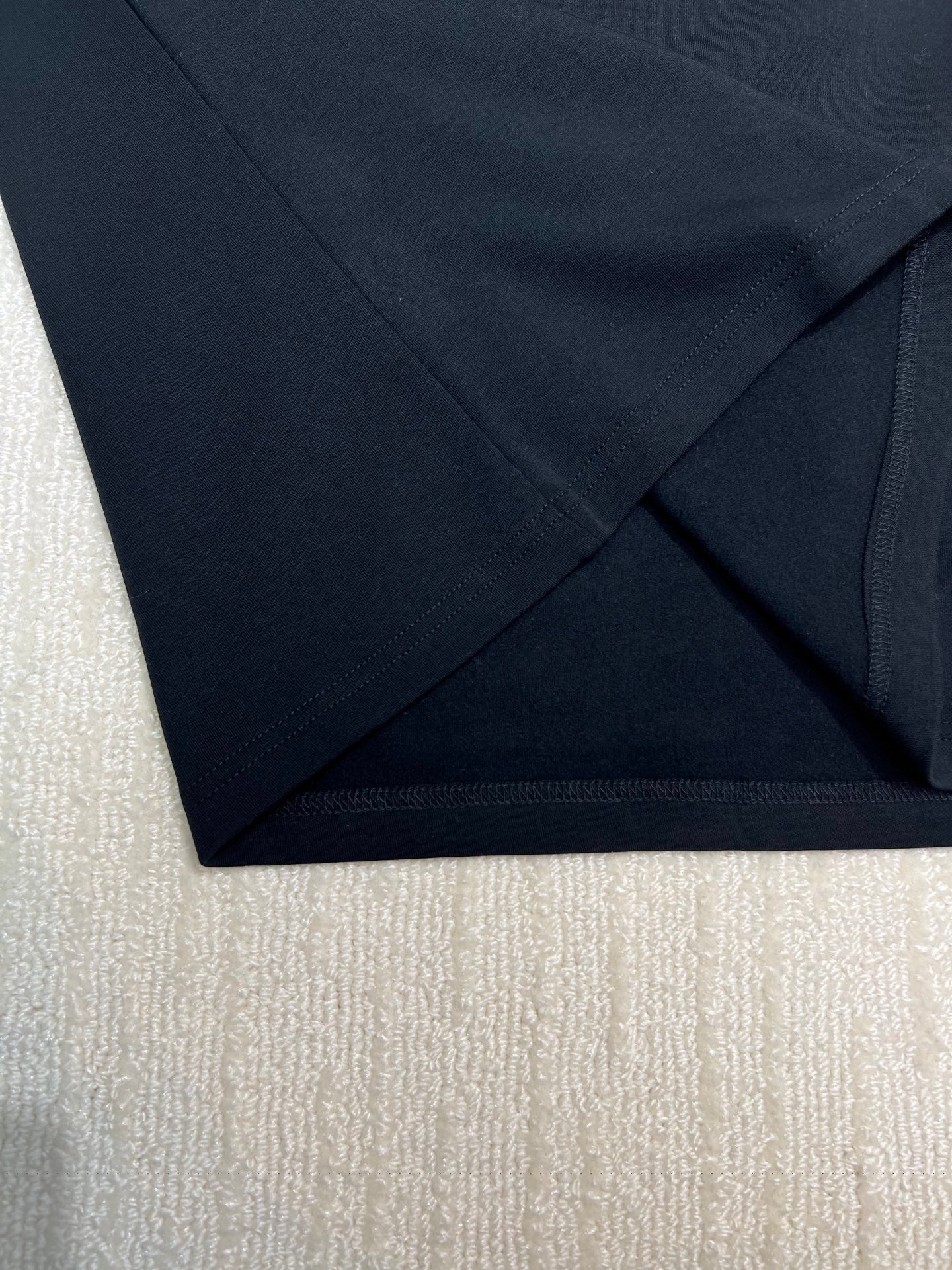 Dark sweatshirt fabric hem and side seam close-up