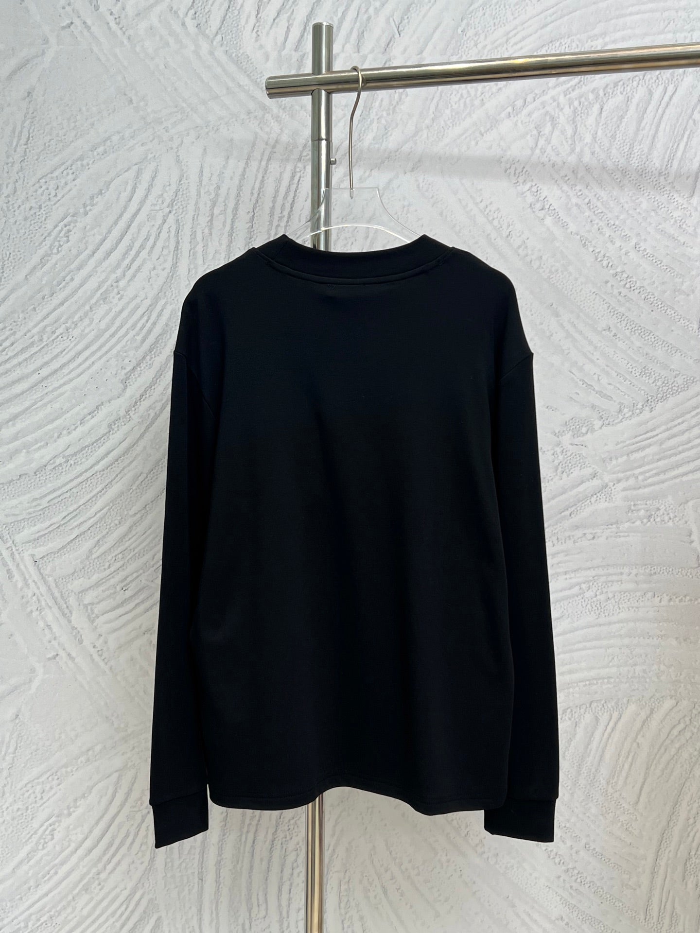 Dark crewneck sweatshirt, back view, long sleeves and ribbed neckline