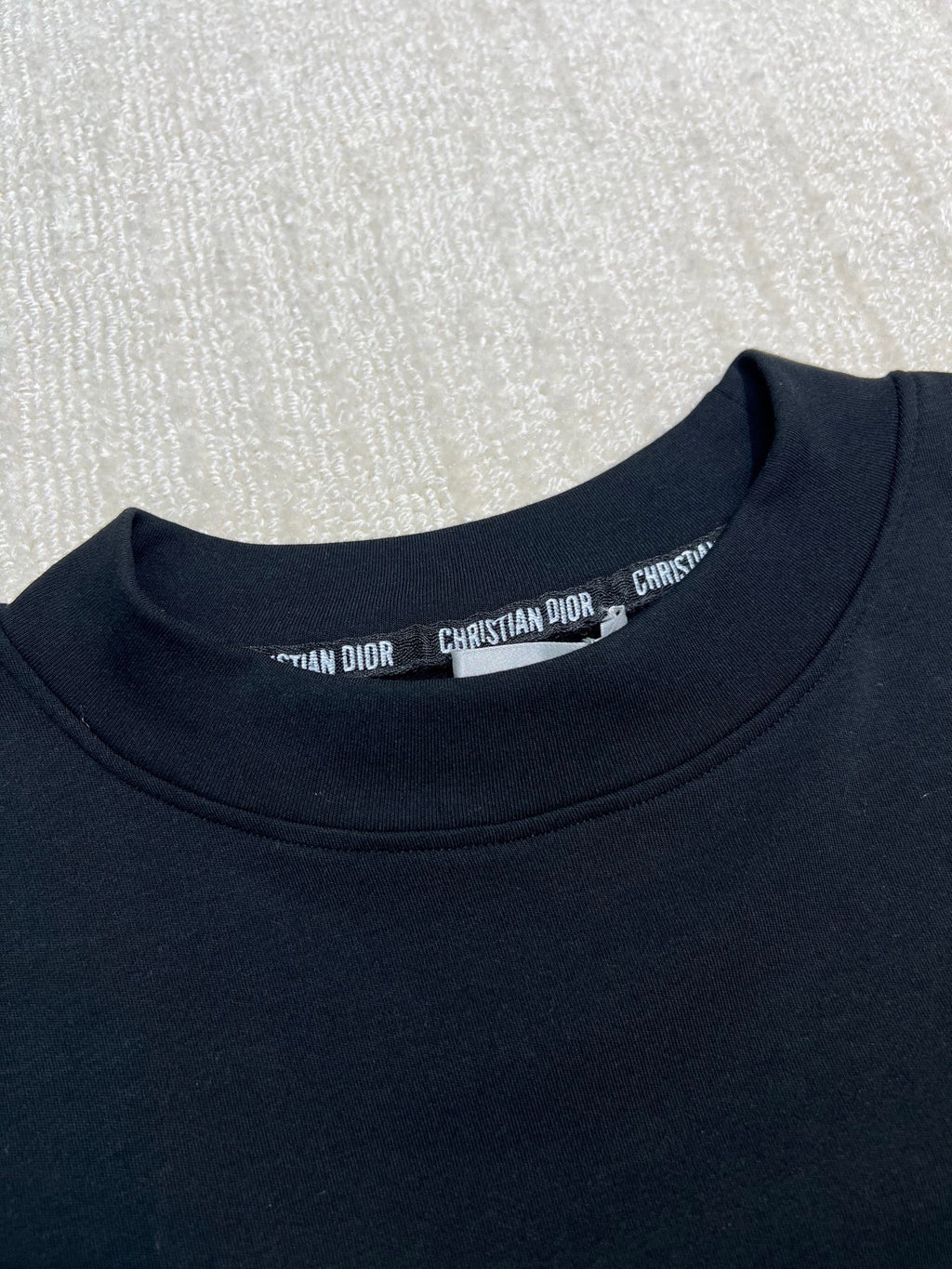 Dark crewneck sweatshirt neckline with small brand print inside collar